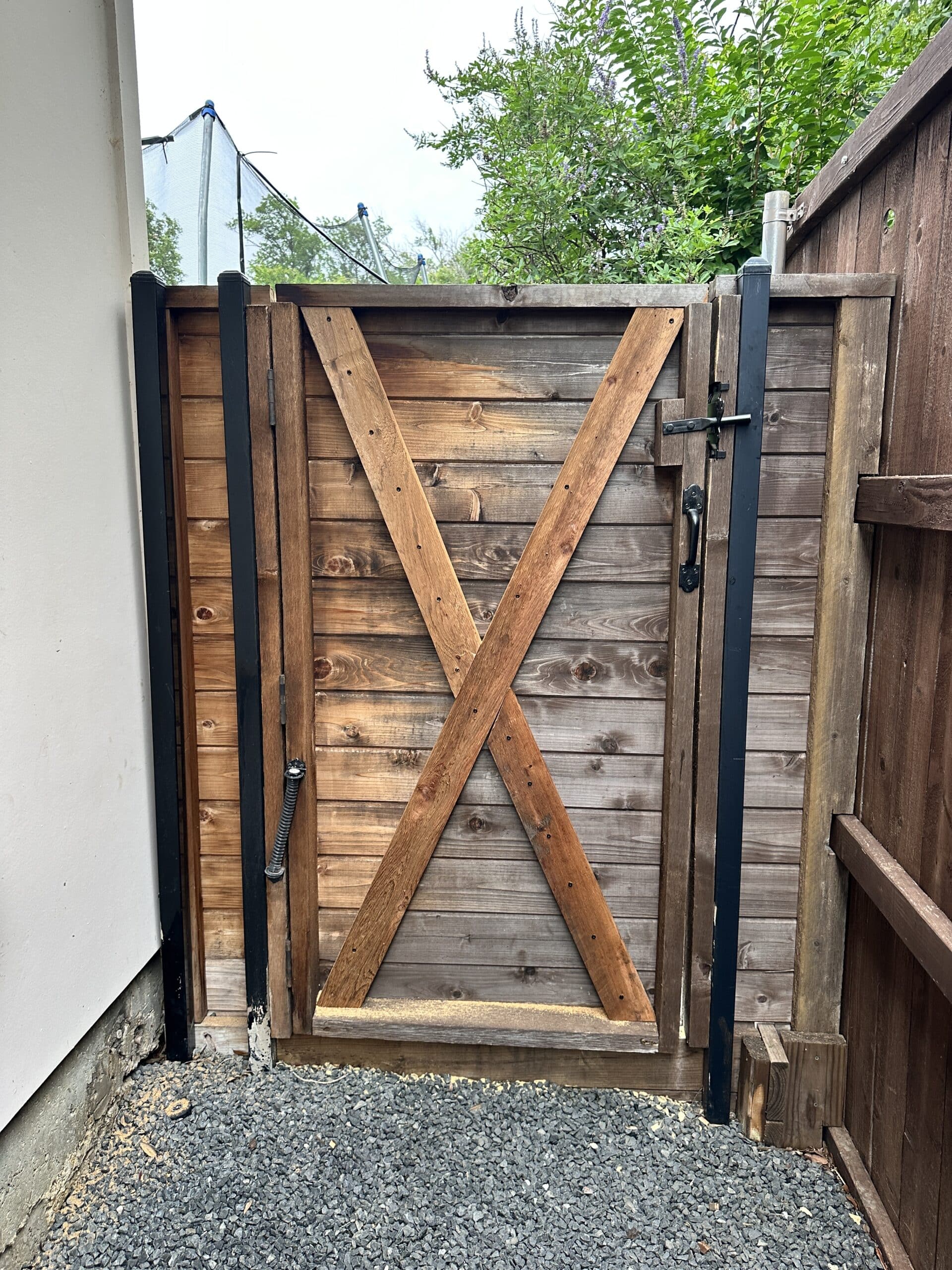 Wood gate rebuilt with X cross-bracing, steel post reinforcement and new latch hardware in Dallas