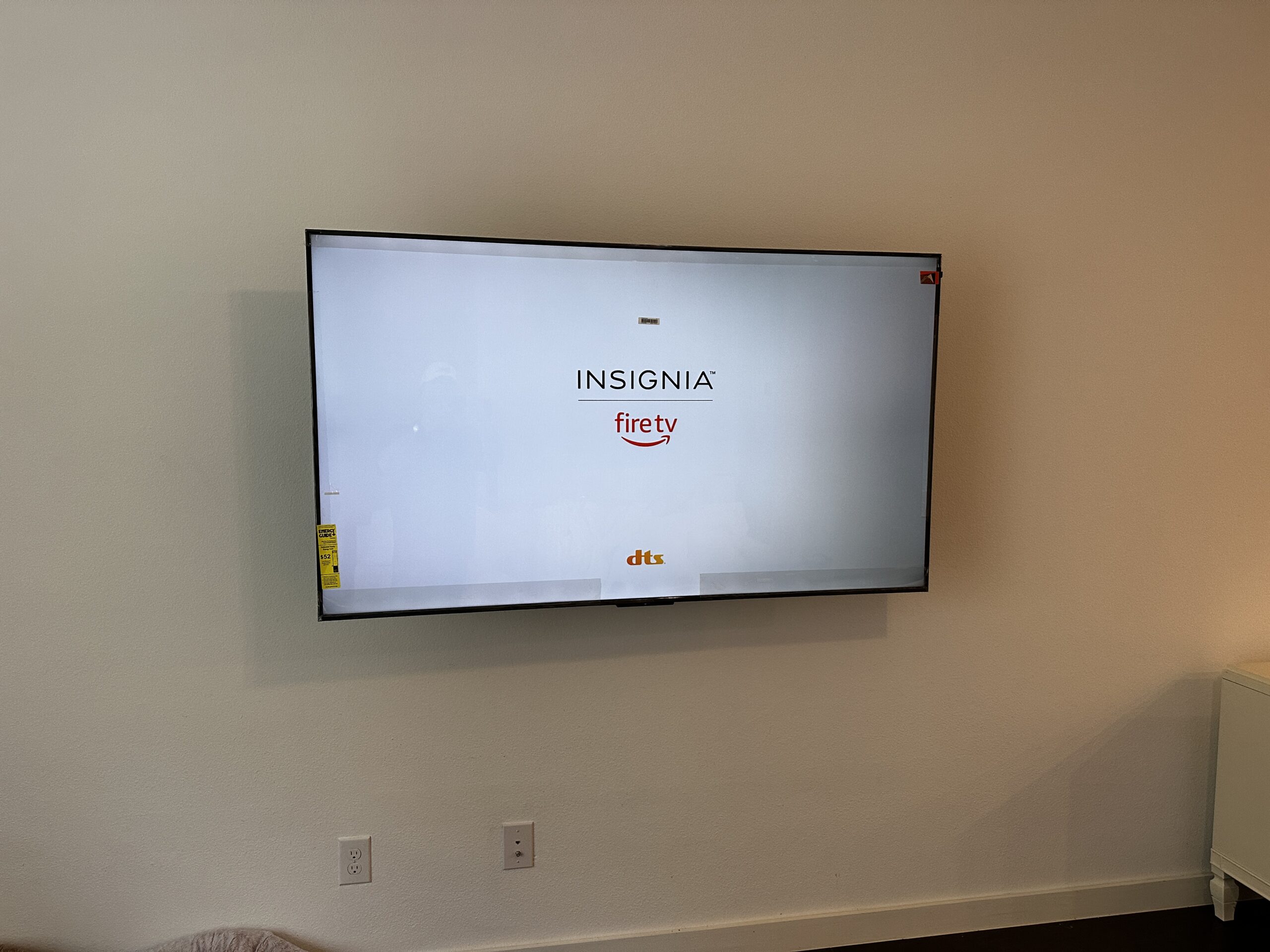 Newly mounted flat-screen TV centered on a living room wall with wiring concealed