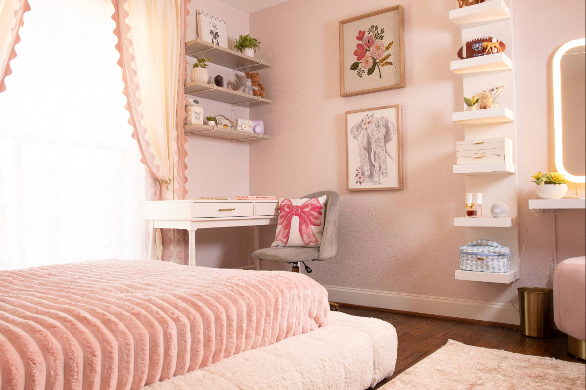 Finished pink girls' bedroom in Lakewood with wall shelves above the desk, a tall shelf unit and a lighted makeup mirror