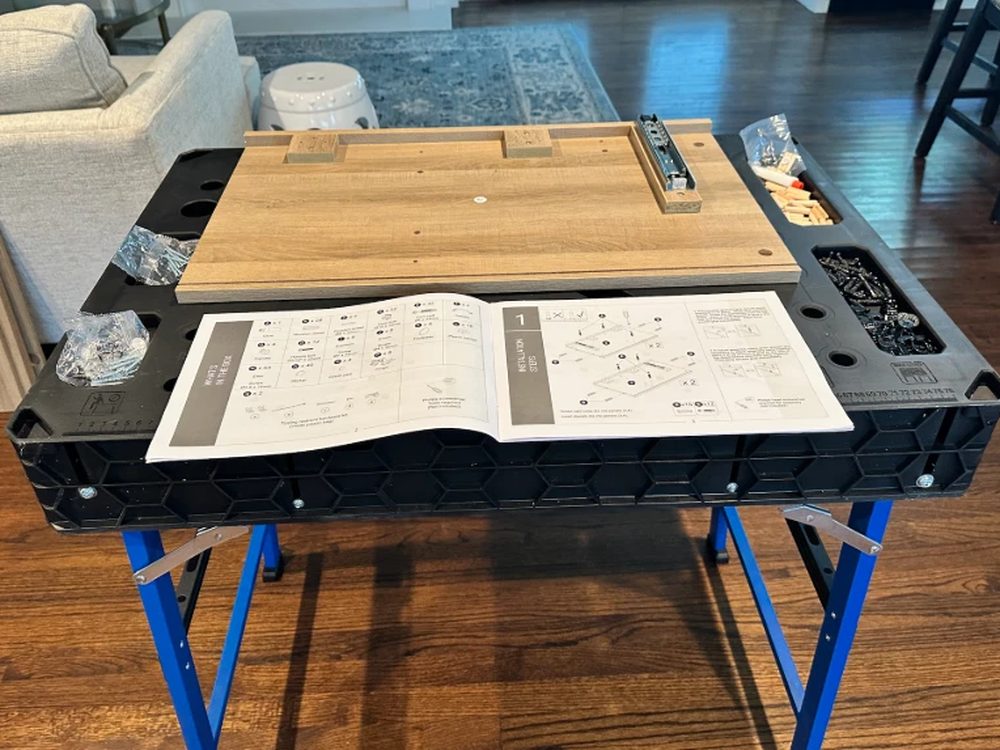 Flat-pack furniture assembly in progress on a workbench in a Dallas home