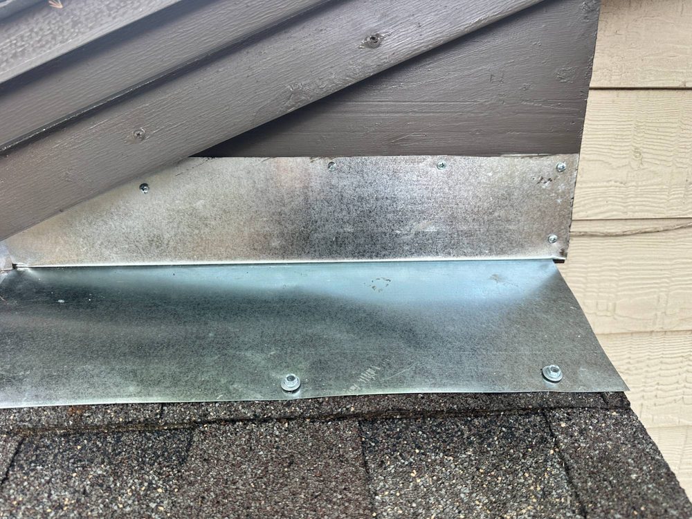 New metal flashing and repaired trim where the roof meets the wall on a Dallas home