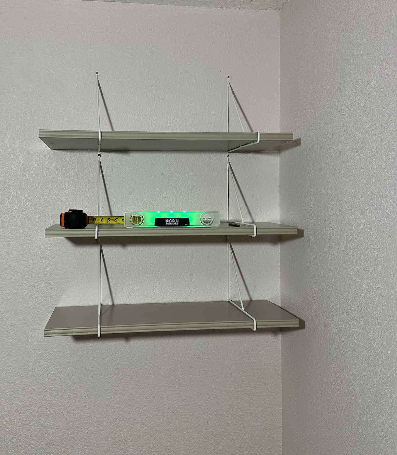 Three wall shelves installed level on sheetrock in a Lakewood bedroom
